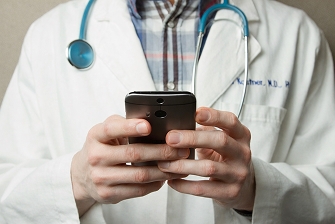 The doctor is looking at the phone